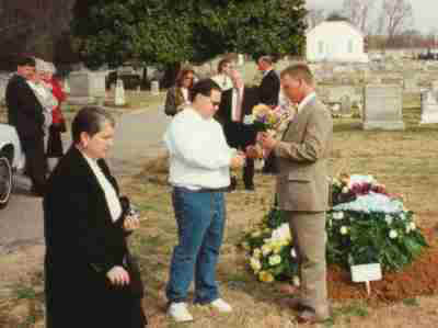 Phil and Kelly collect rememberances from Larry's grave